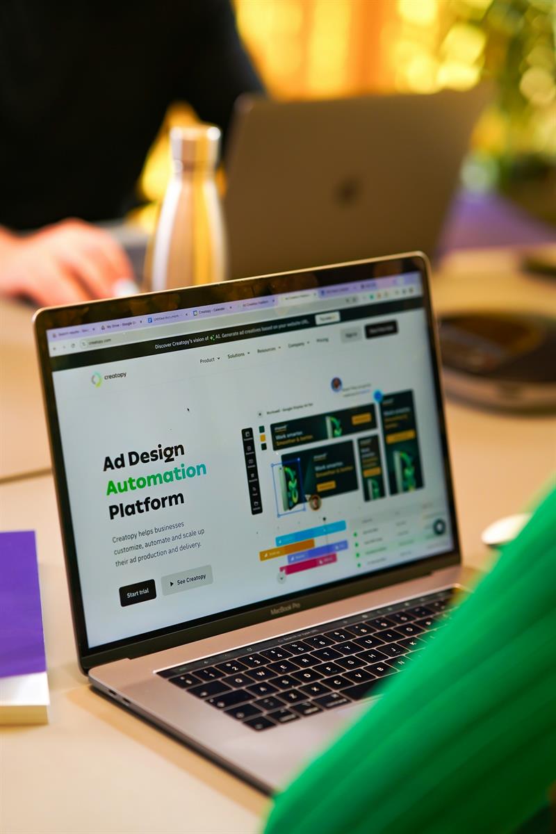 Aufgeklappter Laptop auf Schreibtisch mit Website einer Ad Design Automation Platform