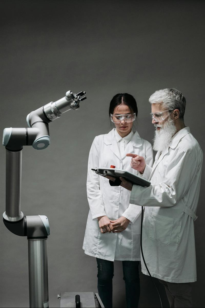 Eine Medizinerin, ein Mediziner und ein medizinisches Gerät mit Roboterarm